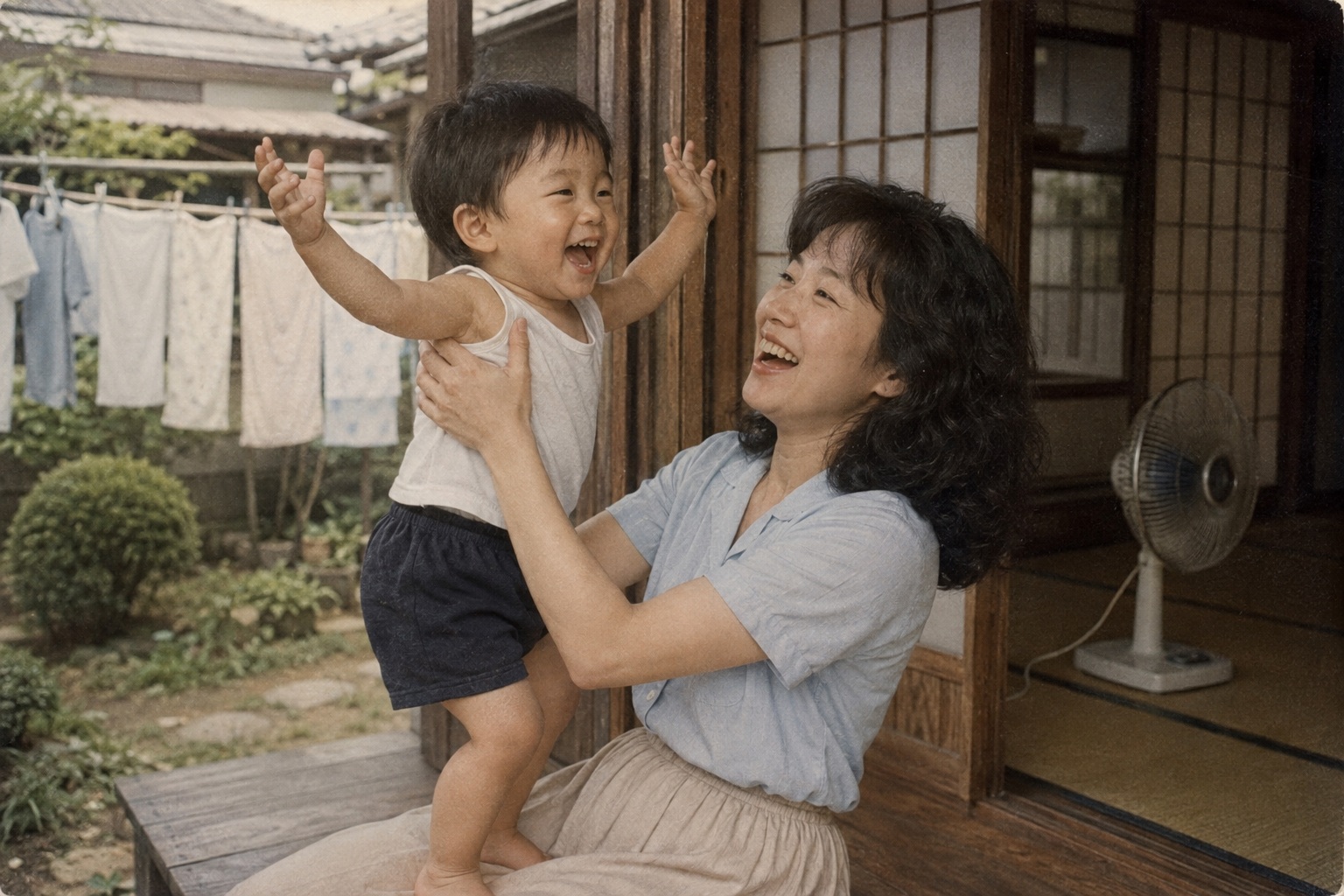 縁側で幼い息子を抱き上げる若い頃の房子