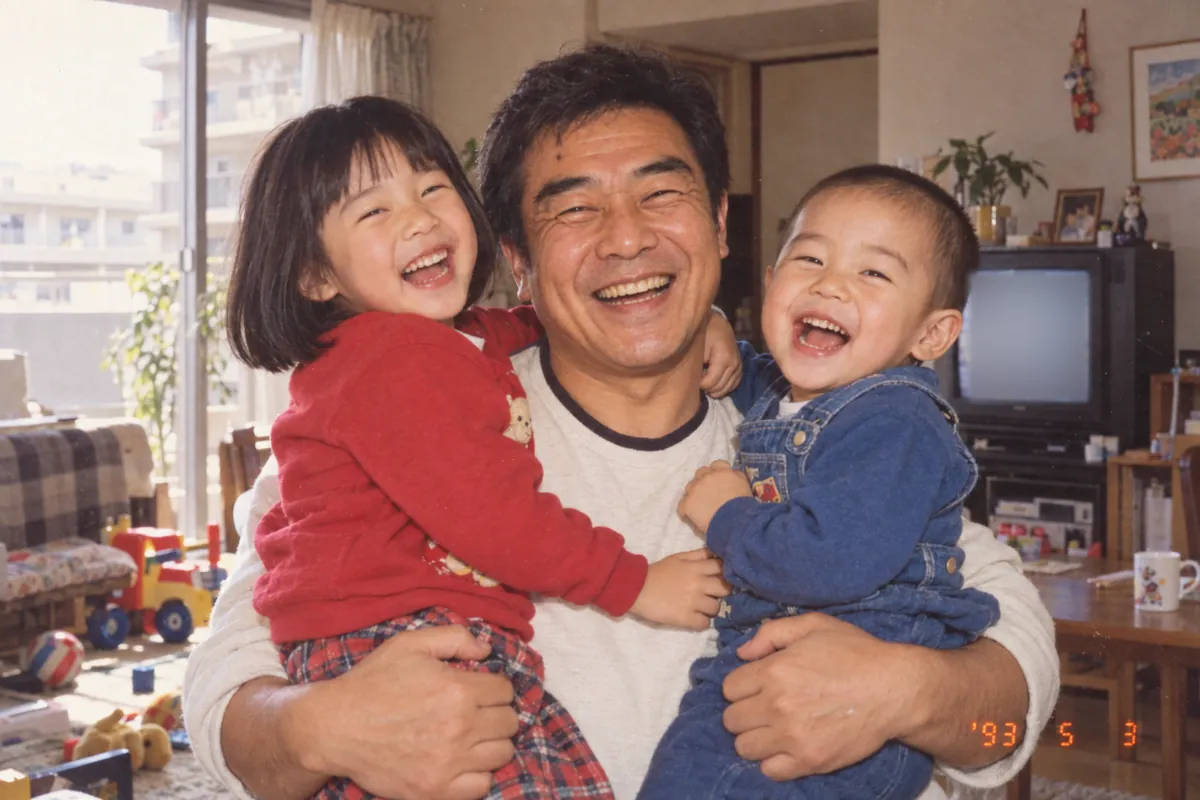 1993年。リビングで、幼いゆかとたくやを両腕に抱いて大笑いするひでお
