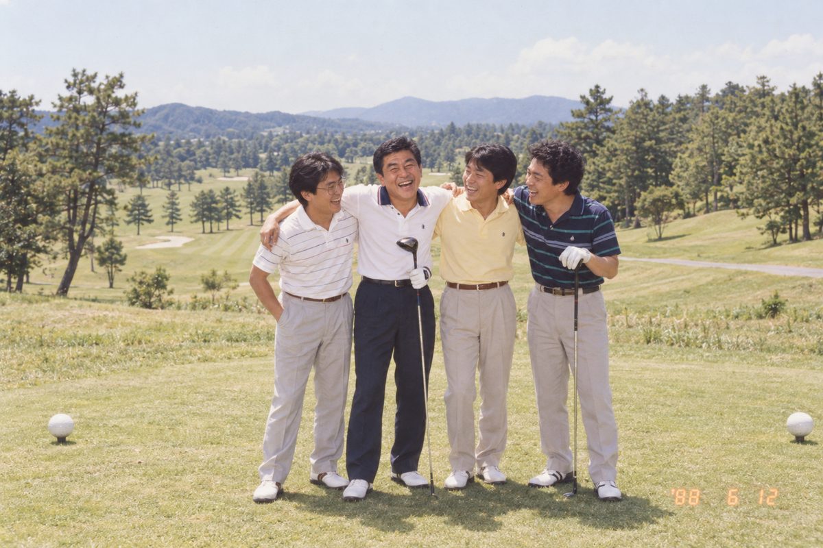 1988年、ゴルフ場で職場の仲間と肩を組んで笑う30歳のひでお